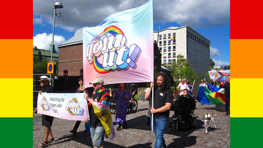 Jesper Persson går längst fram i pride-tåget och håller i en stor skylt